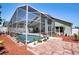 Exterior shot of a screened-in pool and patio area, with lush landscaping around the perimeter at 4381 Creekside Blvd, Kissimmee, FL 34746