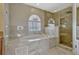 Large bathroom with a tub, glass-enclosed shower, and modern fixtures, perfect for relaxation and comfort at 4574 Ficus Tree Rd, Kissimmee, FL 34758