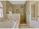 The bathroom features a separate shower, a jacuzzi tub, neutral stone tiling, and a recessed light at 4574 Ficus Tree Rd, Kissimmee, FL 34758