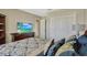 Bedroom with a comfortable bed, TV, and closet doors, creating a relaxing and organized living space at 4574 Ficus Tree Rd, Kissimmee, FL 34758
