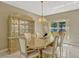 A dining area includes a decorative cabinet, marble table, and a window overlooking the outdoor pool area at 4574 Ficus Tree Rd, Kissimmee, FL 34758