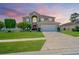 Beautiful two-story home with landscaped yard, driveway, and colorful evening sky at 4574 Ficus Tree Rd, Kissimmee, FL 34758