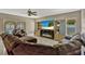 A living room with tile flooring, recessed lighting, a mounted TV, and windows offer a view of the pool at 4574 Ficus Tree Rd, Kissimmee, FL 34758