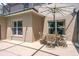 Covered patio with neutral-toned walls, white trim windows, and an outdoor dining set, creating a relaxing space at 4574 Ficus Tree Rd, Kissimmee, FL 34758