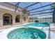 Screened-in pool and hot tub featuring an attached covered patio space with an outdoor seating and barbeque at 4574 Ficus Tree Rd, Kissimmee, FL 34758
