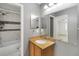This bathroom features a vanity, a mirror, and a shower with gray and white tile at 4584 Pheasant Run Dr # B, Orlando, FL 32808