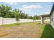 Expansive backyard featuring a modern white fence and newly planted trees at 4713 Jasmine Cir, Leesburg, FL 34748