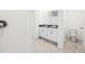 Bright bathroom featuring double sinks, white cabinets, and tile flooring at 4713 Jasmine Cir, Leesburg, FL 34748