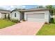 Inviting single-story home with a brick driveway and attached two-car garage at 4713 Jasmine Cir, Leesburg, FL 34748