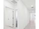 Hallway with tile floors and white doors leading to the home's bedrooms and bathrooms at 4713 Jasmine Cir, Leesburg, FL 34748