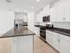 Modern kitchen featuring stainless steel appliances, gray countertop, and an island with a sink at 4713 Jasmine Cir, Leesburg, FL 34748