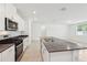 Modern kitchen featuring stainless steel appliances, gray countertop, and an island with a sink at 4713 Jasmine Cir, Leesburg, FL 34748