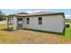 The back exterior features a covered patio with brick flooring and a spacious backyard area at 4717 Jasmine Cir, Leesburg, FL 34748