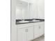 Modern bathroom featuring double sinks, granite counters and updated white cabinets at 4717 Jasmine Cir, Leesburg, FL 34748