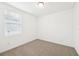 Bright bedroom features neutral carpet, a window with blinds, and fresh white paint at 4717 Jasmine Cir, Leesburg, FL 34748
