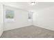 Bright bedroom with plush carpeting and two windows at 4717 Jasmine Cir, Leesburg, FL 34748