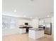 Bright kitchen features white cabinets, stainless steel appliances, and a center island with sink and countertop at 4717 Jasmine Cir, Leesburg, FL 34748