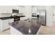 Close-up of a kitchen island with a double sink, surrounded by white cabinets and stainless steel appliances at 4717 Jasmine Cir, Leesburg, FL 34748