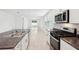 Modern kitchen with stainless appliances, gas range, island sink, white cabinets, and sliding doors to the backyard at 4717 Jasmine Cir, Leesburg, FL 34748
