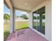 Covered patio area showcasing brick flooring and large sliding glass doors to enter into the home at 4717 Jasmine Cir, Leesburg, FL 34748