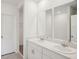 Bathroom featuring double sinks, white cabinets, and a walk-in closet at 4728 Jasmine Cir, Leesburg, FL 34748