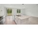 Kitchen island with stainless steel sink next to a sliding glass door and backyard at 4728 Jasmine Cir, Leesburg, FL 34748