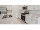 Modern kitchen featuring stainless steel appliances, quartz countertops and all-white cabinetry at 4728 Jasmine Cir, Leesburg, FL 34748