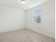 A sunlit, neutral bedroom has a large window and beige floor tiles creating a calm and inviting atmosphere at 4732 Jasmine Cir, Leesburg, FL 34748