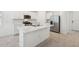 Bright kitchen features white cabinets, stainless steel appliances, and a central island with a quartz countertop at 4732 Jasmine Cir, Leesburg, FL 34748