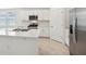 Bright kitchen features an island with a stainless steel sink, white cabinets and modern appliances at 4732 Jasmine Cir, Leesburg, FL 34748