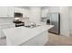 Modern kitchen boasts stainless steel appliances, white cabinetry, and an island with a sink at 4732 Jasmine Cir, Leesburg, FL 34748