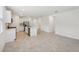 Open floor plan with modern kitchen featuring white cabinets, stainless steel appliances, and spacious adjoining living area at 4732 Jasmine Cir, Leesburg, FL 34748