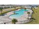 Aerial view of a community pool featuring palm trees, lounge chairs, and a fenced-in perimeter at 4981 Kaia Ave, Winter Haven, FL 33884