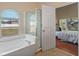 Bright bathroom featuring a soaking tub, glass-enclosed shower, and arched window bringing in natural light at 5537 Misty Woods Dr, Oviedo, FL 32765