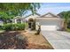 Charming single-Gathering home with well-maintained lawn, two-car garage, and classic architectural details at 5537 Misty Woods Dr, Oviedo, FL 32765