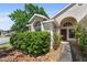 Close-up of a charming front door framed by lush landscaping and a welcoming walkway at 5537 Misty Woods Dr, Oviedo, FL 32765
