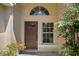 Inviting front entrance featuring a classic door, window, and lush greenery for added privacy at 5537 Misty Woods Dr, Oviedo, FL 32765