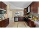 This kitchen has granite countertops, tile floors, stainless steel appliances and dark wood cabinets at 5537 Misty Woods Dr, Oviedo, FL 32765