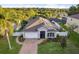 Aerial view of a charming home with a well-manicured lawn and a brick driveway at 600 Rob Roy Dr, Clermont, FL 34711