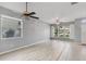 Bright living room with wood floors, ceiling fan, and large windows offering neighborhood views at 600 Rob Roy Dr, Clermont, FL 34711