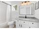 Bright bathroom features a vanity with granite countertop, white tiled shower and modern fixtures at 6426 Sw 60 Ave, Ocala, FL 34474
