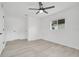 Spacious bedroom with modern gray flooring, neutral walls, a ceiling fan, and bright window at 6426 Sw 60 Ave, Ocala, FL 34474