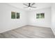 Bright bedroom with modern ceiling fan, windows, and light gray laminate flooring at 6426 Sw 60 Ave, Ocala, FL 34474
