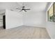An empty living room offers lots of light and new flooring and an decorative ceiling fan at 6426 Sw 60 Ave, Ocala, FL 34474