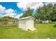 Outdoor shed with a ramp, perfect for extra storage in a lush, green backyard at 6426 Sw 60 Ave, Ocala, FL 34474