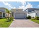 Two-story home with a two-car garage and brick-paved driveway under a partly cloudy sky at 6442 Pine Warbler Way, St Cloud, FL 34771