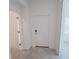 Clean, white hallway featuring a doorway and closet providing access to various rooms at 6442 Pine Warbler Way, St Cloud, FL 34771