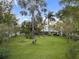 Lush green backyard with palm trees and other mature trees offering privacy and shade at 655 Eagle Pointe South, Kissimmee, FL 34746