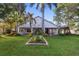 Landscaped backyard view of the home with lawn and mature trees at 655 Eagle Pointe South, Kissimmee, FL 34746