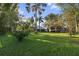 Large backyard featuring mature trees, a well-kept lawn, and lush landscaping at 655 Eagle Pointe South, Kissimmee, FL 34746